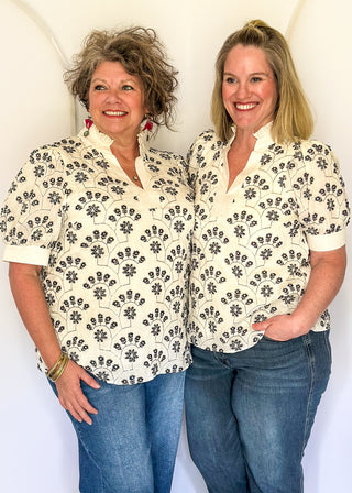 White short sleeve top with navy floral embroidery.
