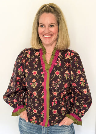 Deep navy floral ruffle trim long sleeve top with rich pink and olive accents.