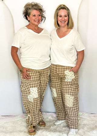 Two women modeling gingham bloomer pants with patches and pockets.