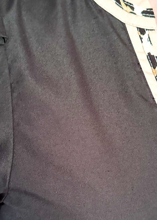 Black puff sleeve knee length dress.  Leopard piping detail on sleeves, v-neck, and at the bottom of the dress. Short sleeve.