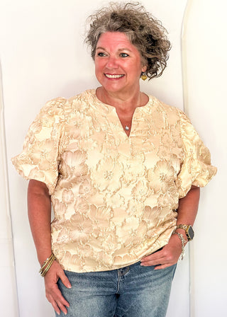 woman in jacquard floral puff sleeve top in champagne.