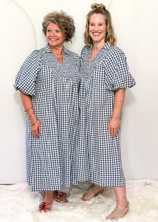 Models wearing long blue gingham dress with short sleeves