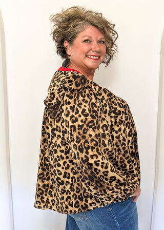 long sleeve leopard print top with red trim v-neck and buttons down the v; ruffle on shoulder 