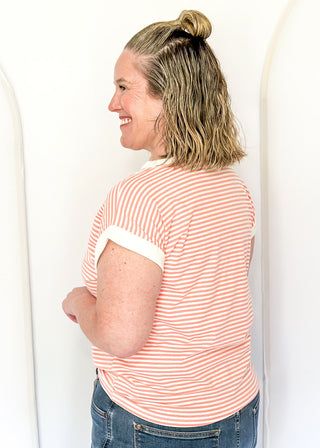 Coral and white stripe short sleeve top with white contrast banding on the collar and sleeves. 