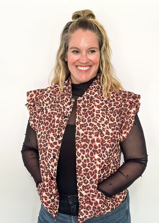 Leopard print Puffer vest with black button closures.  2 front pockets and ruffle detail on the sleeve. 