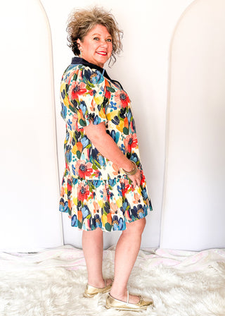 Vibrant watercolor floral dress with short sleeves, lined fabric, tiered hem, and pockets