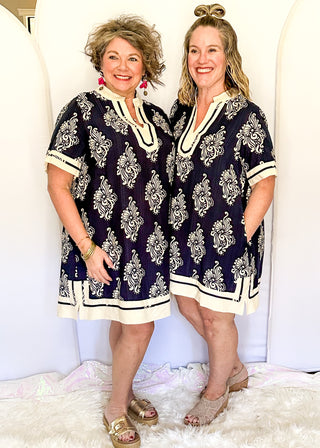 Navy printed short dress with cream contrast trim on the neckline, sleeves, and hem
