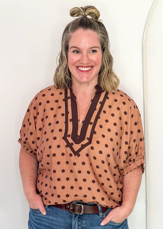 woman in camel dolman top with chocolate polka dots.