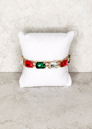 Red, Clear, and Green gemstone bracelet displayed on a stand 