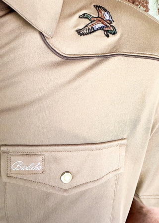 tan western style polo w/pearl snaps, front pocket on left side and embroidered ducks on either shoulder