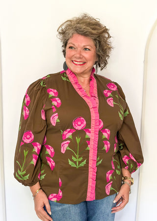 pink florals on brown long sleeve top with shades of pink ruffle around collar and down the front - button up