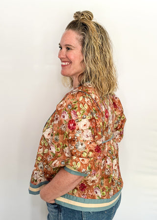 Fall floral Babydoll top with 3/4 puff sleeve, cream and blue strip detail on banding of hem and sleeve. blue ribbon detail on the front and tie at the collar. 