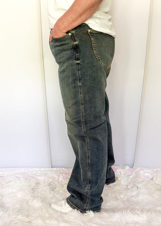 Person wearing blue jeans standing on a white fluffy surface with a white curtain background