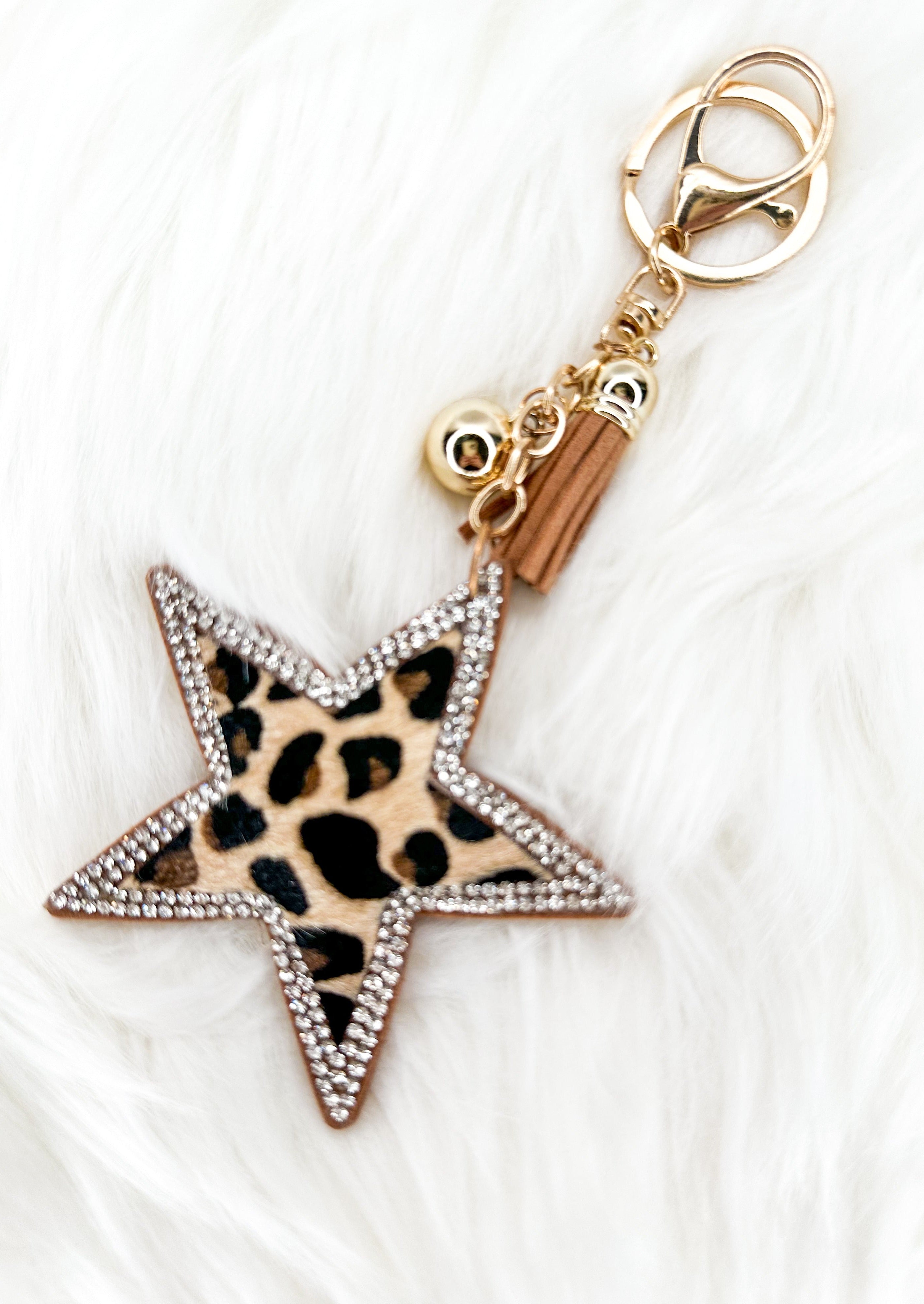 Leopard star keychain trimmed in silver sparkles with gold tassel and hardware.