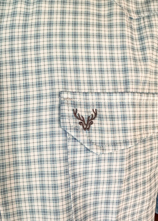 Close-up of a plaid short-sleeve button-up shirt in white and light blue, featuring a chest pocket with a small embroidered deer head logo.