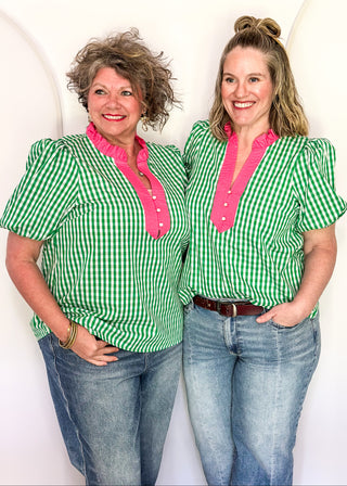 Women’s gingham blouse with decorative buttons and statement neckline detail.