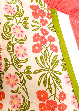 Close up of floral print top with decorative neckline and short ruffle sleeves