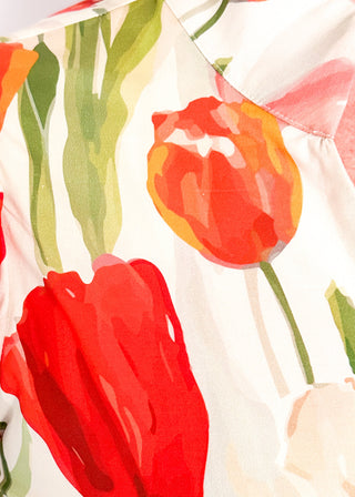 Close up of tulip print midi dress with short sleeves, smocked waist, pockets, and lined fabric