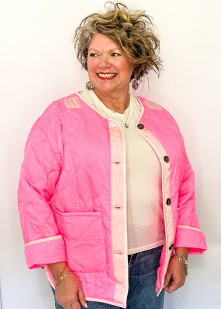 Bright pink quilted jacket with light pink contrast trim, long sleeves, patch pockets, and button-front closure