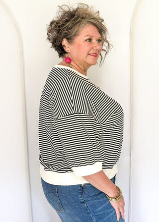Striped knit dolman top with crew neckline and ribbed trim in black.