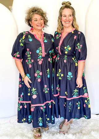Colorful floral navy midi dress featuring pink contrast trim and a gathered waistline
