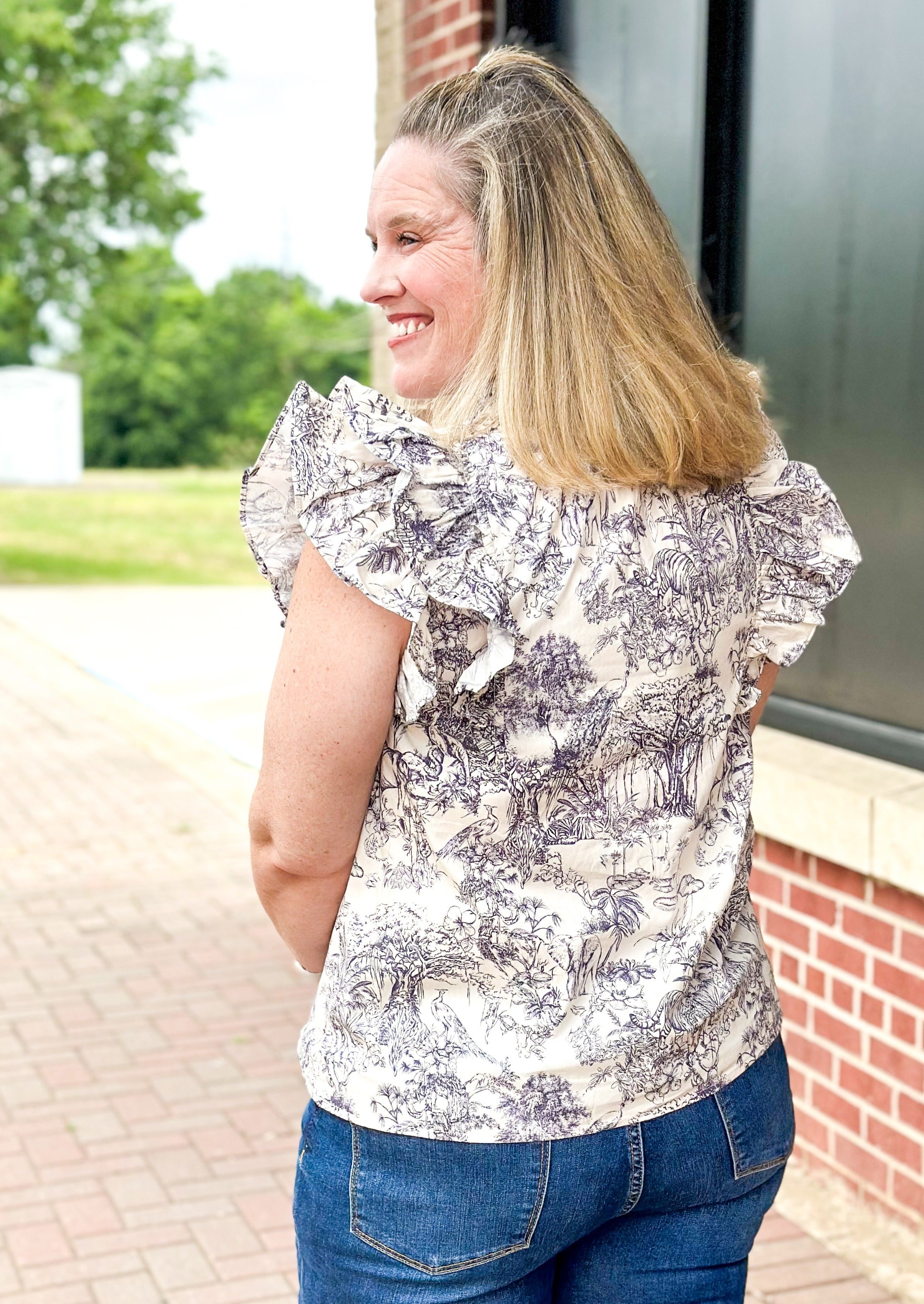 off white double ruffle short sleeve top with ruffle tie v-neck - jungle print scene in a bluish gray