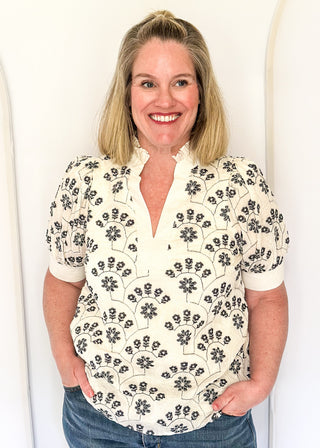 White short sleeve top with navy floral embroidery.