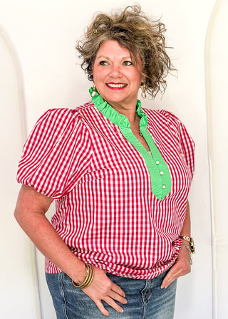 Women’s gingham blouse with decorative buttons and statement neckline detail.