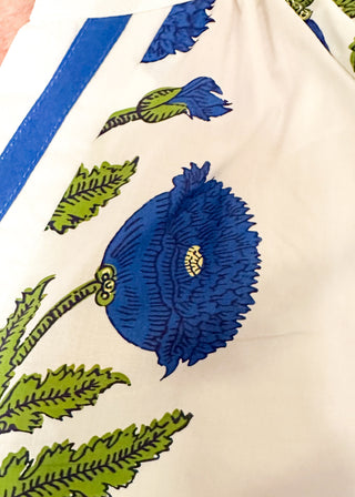 3/4 smocked sleeve white top with large blue blooms. V-neck with blue piping detail. 