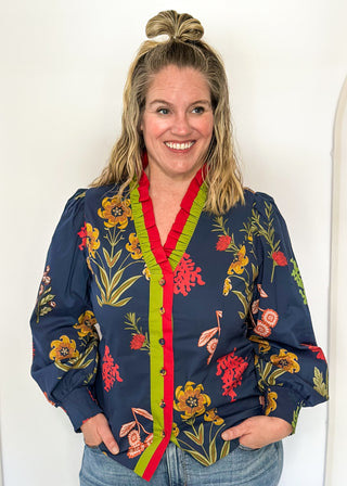 floral long sleeve top with navy background and redish and gold blooms - red and green ruffle around collar and down front - button up