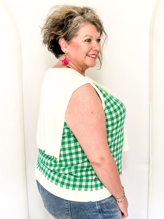 Sleeveless green checkered sweater with faux wrap in cream.