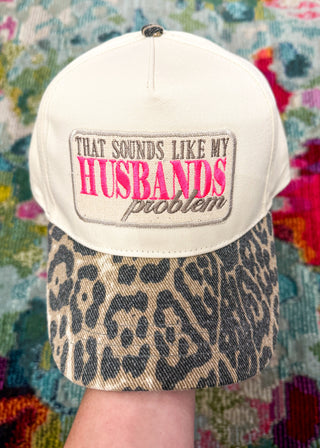 Snap-back canvas hat with leopard bill.  Embroidered patch with "That Sounds Like My Husbands Problem" in taupe and hot pink.