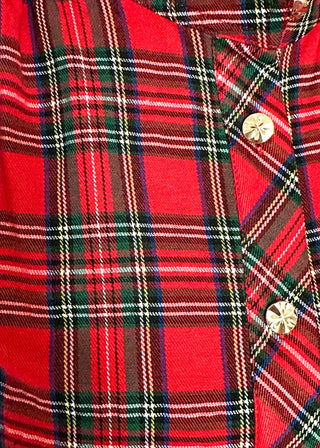 Close-up of a red tartan plaid shirt with green, white, and black stripes, featuring decorative gold buttons on the placket.
