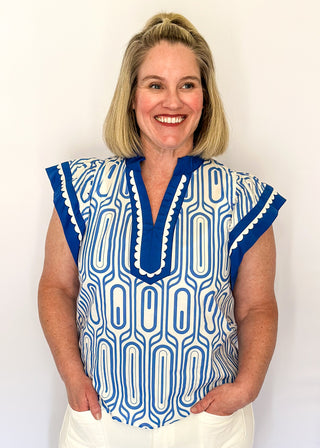 Patterned short-sleeve top in blue with contrast trim with scallops, v-neckline.