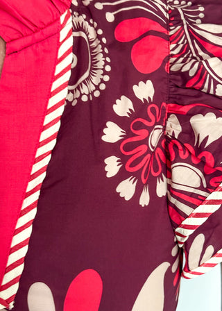 close up of plum blouse with bold cream and pink florals; flutter sleeves, and striped neckline