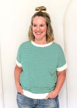 Woman wearing a green and white striped shirt against a white background