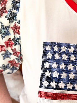Close up of sequin flag with red and blue sequin star sleeves and red contrast banding on collar. 