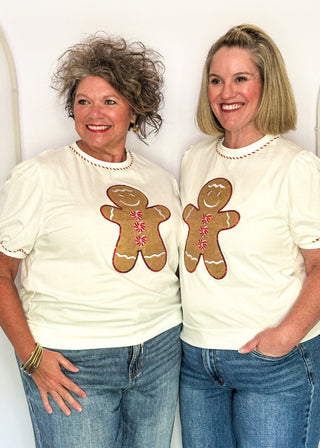 Two women modeling a short sleeve puff sleeve top with fabric gingerbread man with sequins and embroidery details
