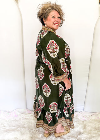 Palm green maxi dress with colorful floral medallion print, orange embroidered trim at neckline, and smocked cuffs