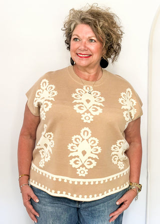 Taupe knit sweater with ivory woven pattern and short sleeves.