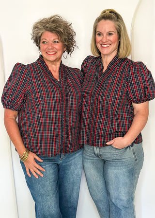 Two women wearing a plaid puff sleeve top in dark navy with short sleeves and a V-neckline.