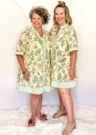 Women's floral dress with sage botanical print, striped seersucker trim, and buttons.