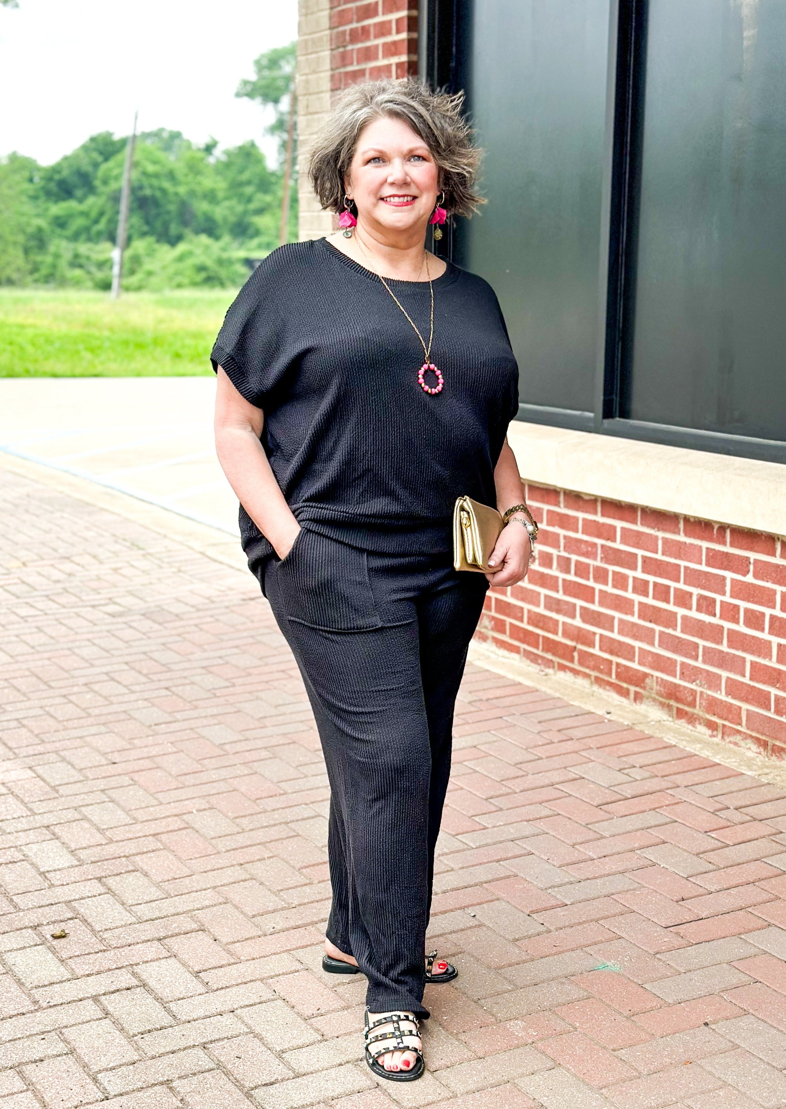 textured black set top and pants - pants have pockets and banded waist - top has a drop shoulder dolman sleeve with banding around the bottom.