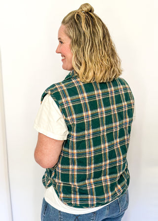 Green plaid puffer vest with snap front and side pockets.