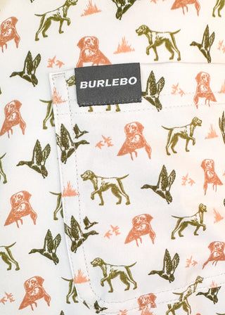 Close-up of a white fabric pocket with an allover print of dog illustrations in orange and olive green, featuring a black BURLEBO brand label.