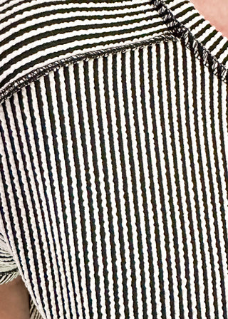 Close-up of a person wearing a black and white striped shirt.