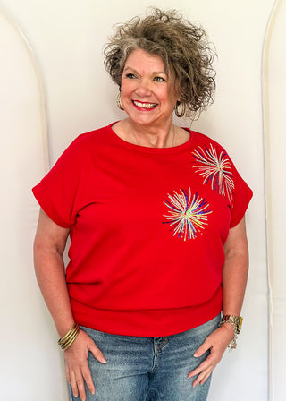 Red short sleeve top with 2 sequin firework bursts.