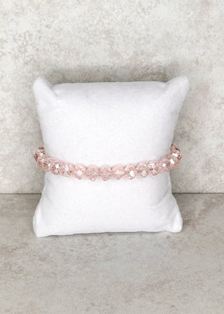 Light pink beaded bracelet displayed on a stand 