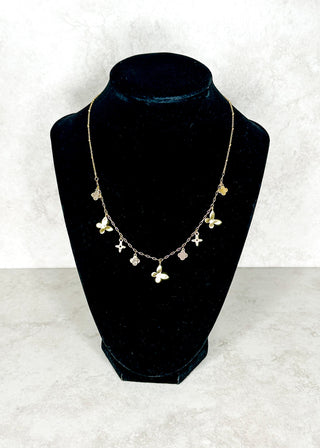 Necklace with butterfly pendants on a black velvet stand against a white background