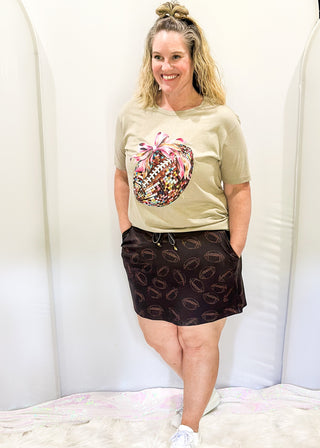 Black Skort with pockets and tie at waist. Brown football pattern throughout.